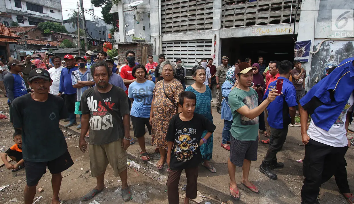 Sejumlah warga menyaksikan pembongkaran bangunan liar di sekitar rusunami Bidaracina, Jakarta Timur, Kamis (14/9). Pembongkaran tersebut bagian dari penertiban bertahap bangunan liar yang tersebar di beberapa Rusunami. (Liputan6.com/Immanuel Antonius)