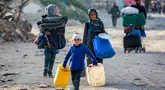 Seorang anak laki-laki berjalan dengan jeriken kosong bersama orang-orang yang mengungsi akibat konflik dan melarikan diri dari Beit Hanun, Jalur Gaza utara tiba di Kota Gaza pada 18 Maret 2025. (Bashar TALEB/AFP)