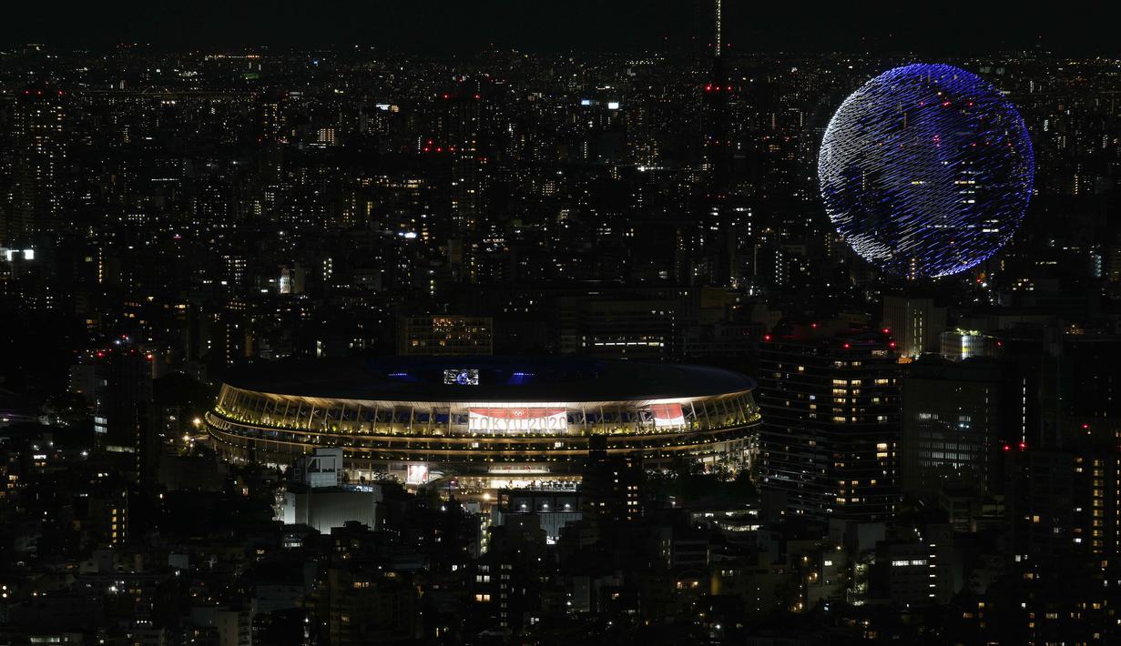 Drone yang membuat formasi menyerupai bola dunia menghiasi langit kota Tokyo saat upacara pembukaan Olimpiade Tokyo 2020, Jumat (23/7/2021). (Foto: AP/Eugene Hoshiko)