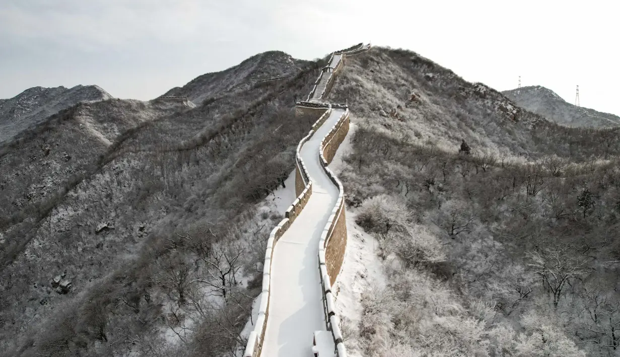 Foto ini menunjukkan pemandangan udara dari bagian Tembok Besar Cina yang tertutup salju di Shuiguan, sebelah utara Beijing, pada 15 Desember 2023. (GREG BAKER/AFP)