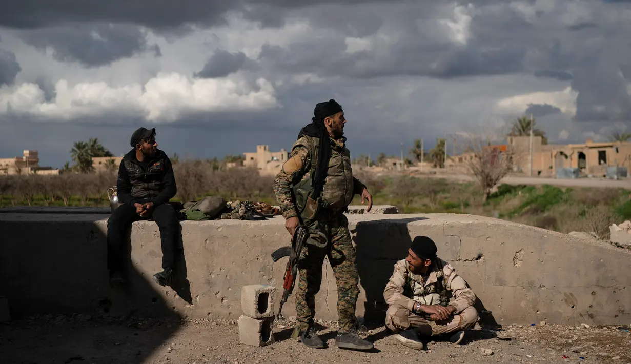 Anggota Syrian Democratic Forces (SDF) mengintai militan ISIS dari sebuah bangunan di kantong terakhir kekhalifahan di Baghouz, Suriah, Senin (18/2). Daerah ini menyisakan militan ISIS paling tangguh, kejam, dan berpengalaman. (AP Photo/Felipe Dana)