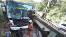 Petugas menggunakan mobil derek untuk mengevakuasi bus PO Merdeka yang menabrak pohon di jalur Lingkar, Jawa Barat, Sabtu (2/7). Kecelakaan terjadi karena rem bus bernopol Z 7829 T itu tidak berfungsi, alias blong. (Liputan6.com/Immanuel Antonius)
