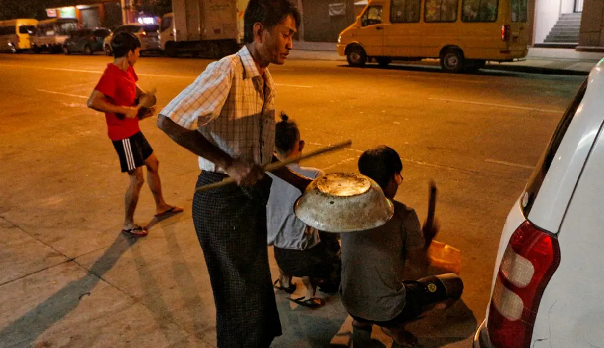 Warga memukul panci, wajan, dan berbagai benda untuk membuat keributan memprotes kudeta militer di Yangon, Myanmar, 2 Februari 202. Warga membunyikan klakson mobil dan panci serta wajan yang berdenting sebagai protes atas kudeta militer Myanmar. (STR/AFP)