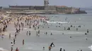 Pengunjung pantai menikmati air di Pantai Carcavelos, di luar Lisbon, Selasa (12/7/2022). Portugal mengalami gelombang panas yang membuat pemerintah mengumumkan keadaan siaga mulai Senin hingga Jumat karena meningkatnya risiko kebakaran hutan. (AP Photo/Armando Franca)