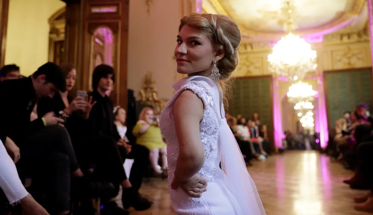 Model berpose ketika menampilkan gaun khusus perempuan bertubuh pendek dalam International Dwarf Fashion Show di Paris, Selasa (26/9). Ajang ini untuk meningkatkan kesadaran di dunia fesyen yang lebih inklusif dan tanpa diskriminasi. (Thomas SAMSON/AFP)