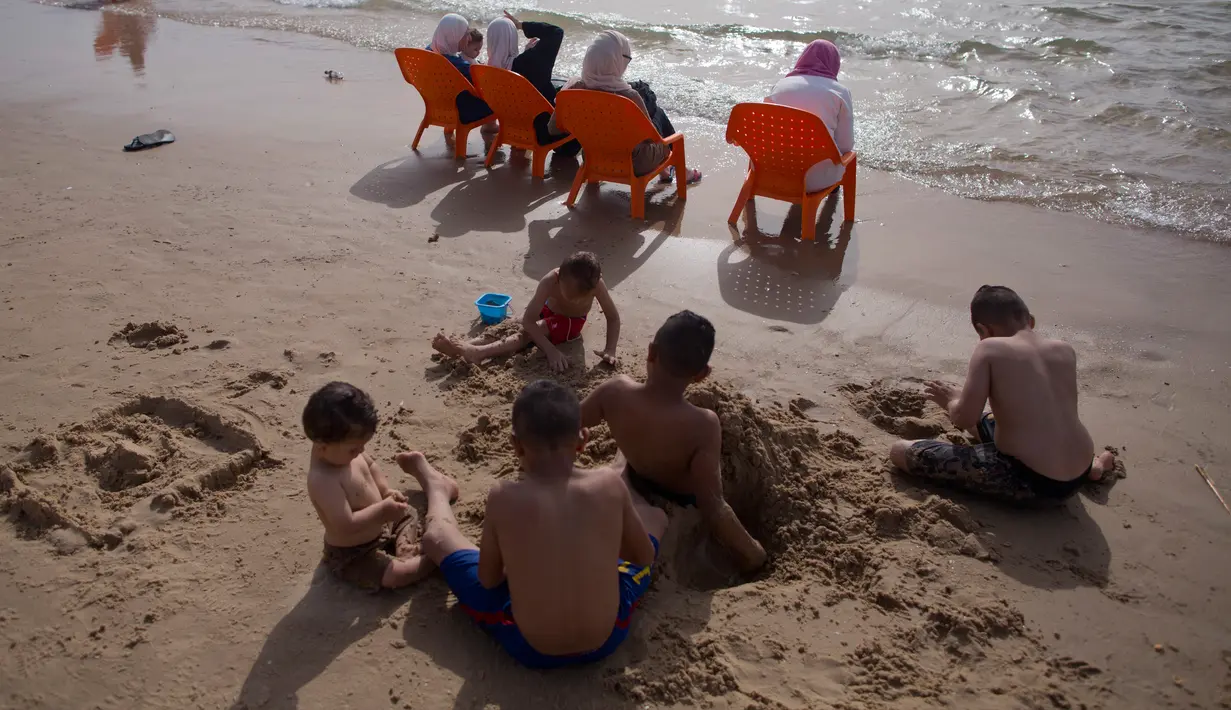 Anak-anak bermain pasir saat menghabiskan libur Idul Fitri di pantai Tel Aviv, Israel, Sabtu (16/6). (AP Photo/Oded Balilty)