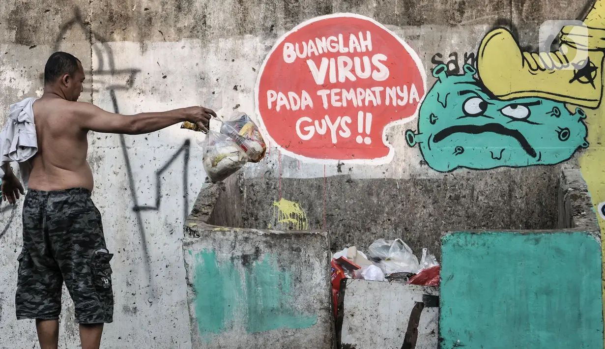 Warga membuang sampah dekat mural bertema imbauan protokol kesehatan COVID-19 di kawasan Cakung Barat, Jakarta, Minggu (18/10/2020). Mural karya warga setempat tersebut bertujuan mengingatkan masyarakat akan pentingnya memakai masker, menjaga jarak, dan mencuci tangan. (merdeka.com/Iqbal S. Nugroho)