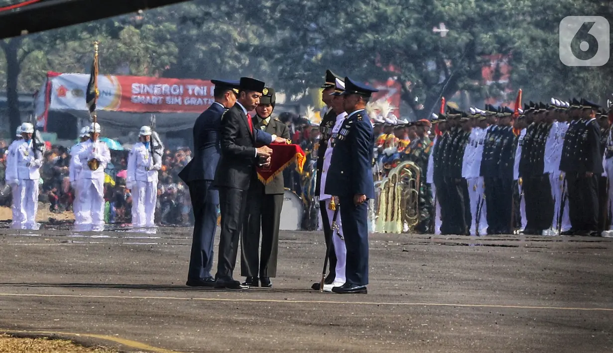 Presiden Joko Widodo atau Jokowi memberi penghargaan kepada prajurit pada perayaan HUT ke-74 TNI di Taxi Way Echo, Lanud Halim Perdanakusuma, Jakarta Timur, Sabtu (5/10/2019). Tiga Prajurit TNI memperoleh penghargaan dari Jokowi. (Liputan6.com/JohanTallo)