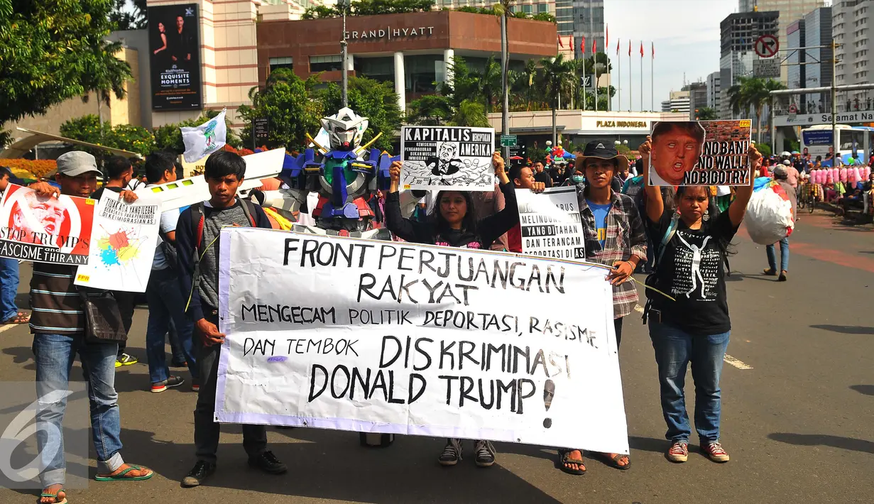 Sejumlah masa yang tergabung dalam front Perjuangan Rakyat membentangkan spanduk dan membawa poster saat melakukan aksi yang mengecam kebijakan Presiden Amerika Serikat Donald Trump di Jakarta, Minggu (5/2). (Liputan6.com/Angga Yuniar)
