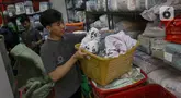 Pekerja penatu mengambil pakaian yang telah selesai dicuci di salah satu tempat layanan penatu di kawasan Ampera Raya, Jakarta, Rabu (17/4/2024). (Liputan6.com/Herman Zakharia)