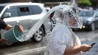 Orang-orang saling memercikkan air di pusat kota Yerevan selama liburan tahunan Vardavar pada 16 Juli 2023. (Photo by Karen MINASYAN / AFP)