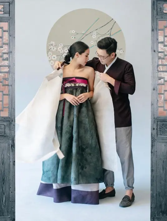 <p>Pamer kemesraan sambil memasangkan durumagi atau jubah hanbok pria, Maudy terlihat begitu elegan meski hanya mengenakan Chima atau bawahan hanbook. (Foto: Instagram/maudyayunda)</p>