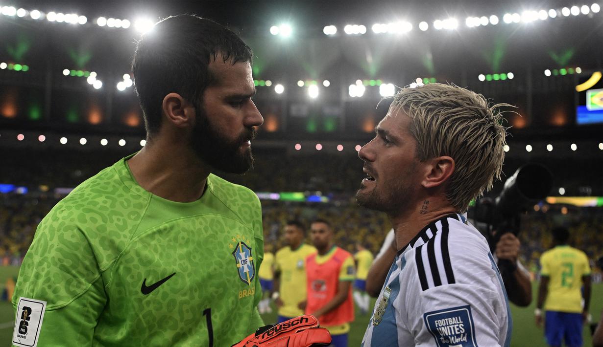 Adu argumentasi terjadi antara kiper Timnas Brasil, Allison Becker (kiri), dengan pemain Timnas Argentina Rodrigo De Paul saat pertandingan Kualifikasi Piala Dunia 2026 Zona CONMEBOL yang berlangsung di Maracana Stadium, Rio de Janeiro, Rabu (22/11/2023) pagi WIB. (AFP/Carl De Souza)