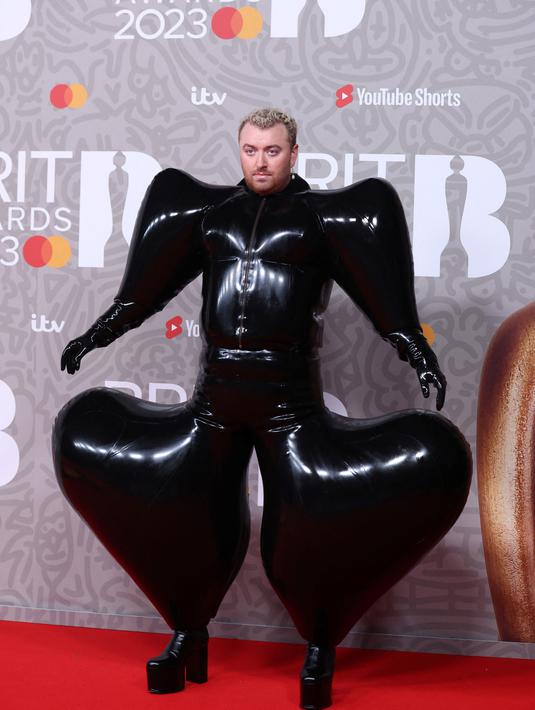 Penyanyi Inggris Sam Smith berpose pada karpet merah Brit Awards 2023 di London, Sabtu (11/2/2023). Gaun tersebut memiliki bentuk yang menggelembung di bagian kaki dan tangan, hingga membuat bentuk tubuh Smith seperti sebuah balon. (Photo by ISABEL INFANTES / AFP)