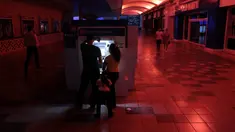 Warga menggunakan mesin ATM di pusat perbelanjaan ketika pemadaman listrik di San Juan, Puerto Rico, Rabu (21/9). Kebakaran yang terjadi di pembangkit listrik Puerto Rico menyebabkan 1,5 juta penduduk pulau itu hidup tanpa listrik. (REUTERS/Alvin Baez)
