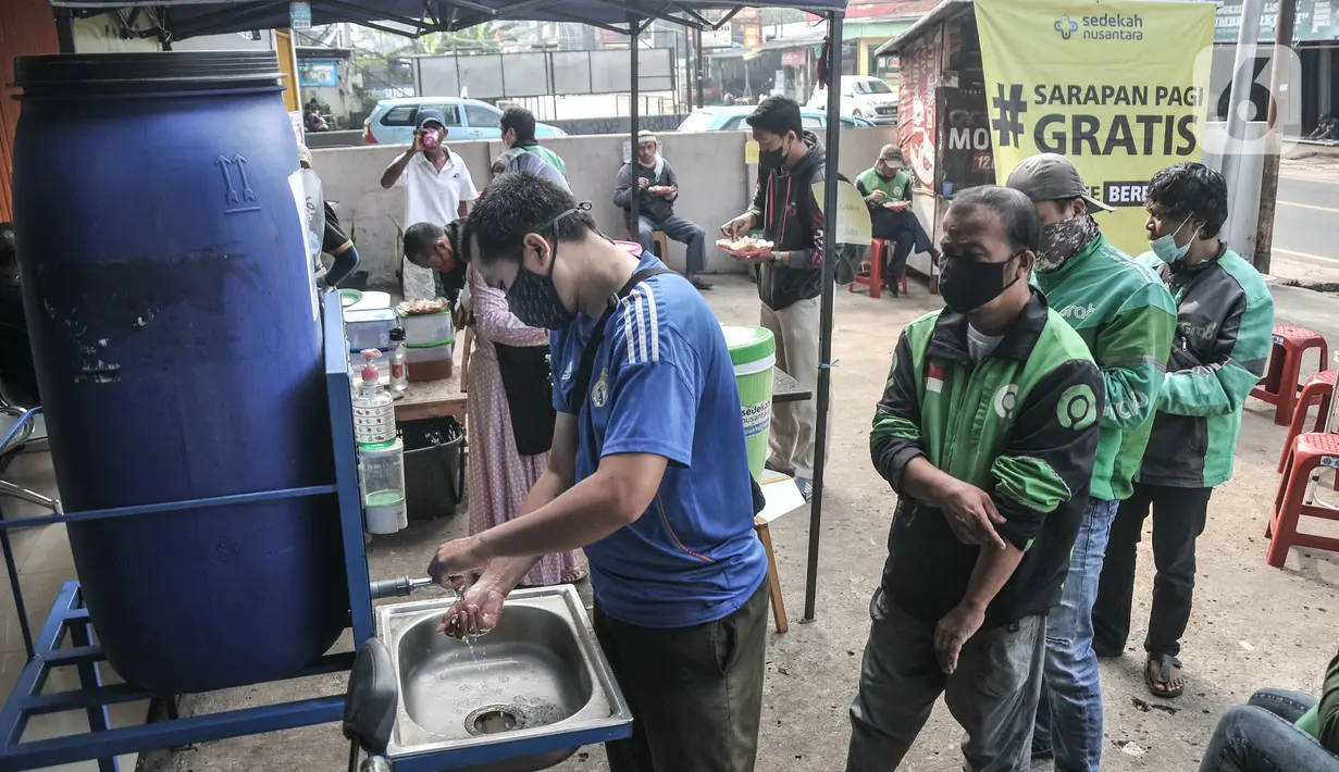 Warga mencuci tangan sebelum menikmati sarapan gratis di Lembaga Sedekah Nusantara, Sawangan, Depok, Minggu (5/9/2021). Lembaga kemanusiaan Sedekah Nusantara menggelar kegiatan berbagi sarapan gratis untuk warga atau pengendara yang melintas di kawasan tersebut (merdeka.com/Iqbal S Nugroho)