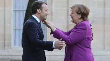Presiden Prancis Emmanuel Macron (kiri) menyambut Kanselir Jerman Angela Merkel saat tiba di Istana Presiden Eylsee di Paris (16/3). Pertemuan tersebut untuk membahas reformasi Uni Eropa. (AFP Photo/Ludovic Marin)