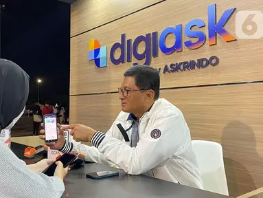 Direktur Utama Askrindo, Priyastomo melayani pengunjung saat transaksi pembelian Asuransi Kecelakaan Diri Askrindo pada aplikasi digiask di booth digiAsk Askrindo di gelaran Java Jazz Festival 2022, Jakarta (29/05/2022). Aplikasi digiAsk dari Askrindo memberikan proteksi asuransi kecelakaan diri untuk seluruh penonton, artis dan crew saat gelaran Java Jazz Festival 2022. (Liputan6.com/HO/Askrindo)