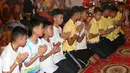 Pelatih tim sepak bola remaja Thailand, Ekkapol Janthawong (empat kanan) bersama 12 anak asuhnya mengikuti ritual setelah berhasil selamat dari dalam gua,  Distrik Mae Sai, Chiang Rai, Kamis (19/7). (AP Photo/Sakchai Lalit)