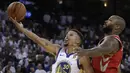 Aksi pebasket Warriors, Stephen Curry (kiri) melakukan tembakan lays up saat diadang pebasket Houston Rockets, PJ Tucker pada laga perdana NBA 2017 di Oracle Arena, Oakland, (17/10/2017).  Rockets menang 122-121. (AP/Ben Margot)