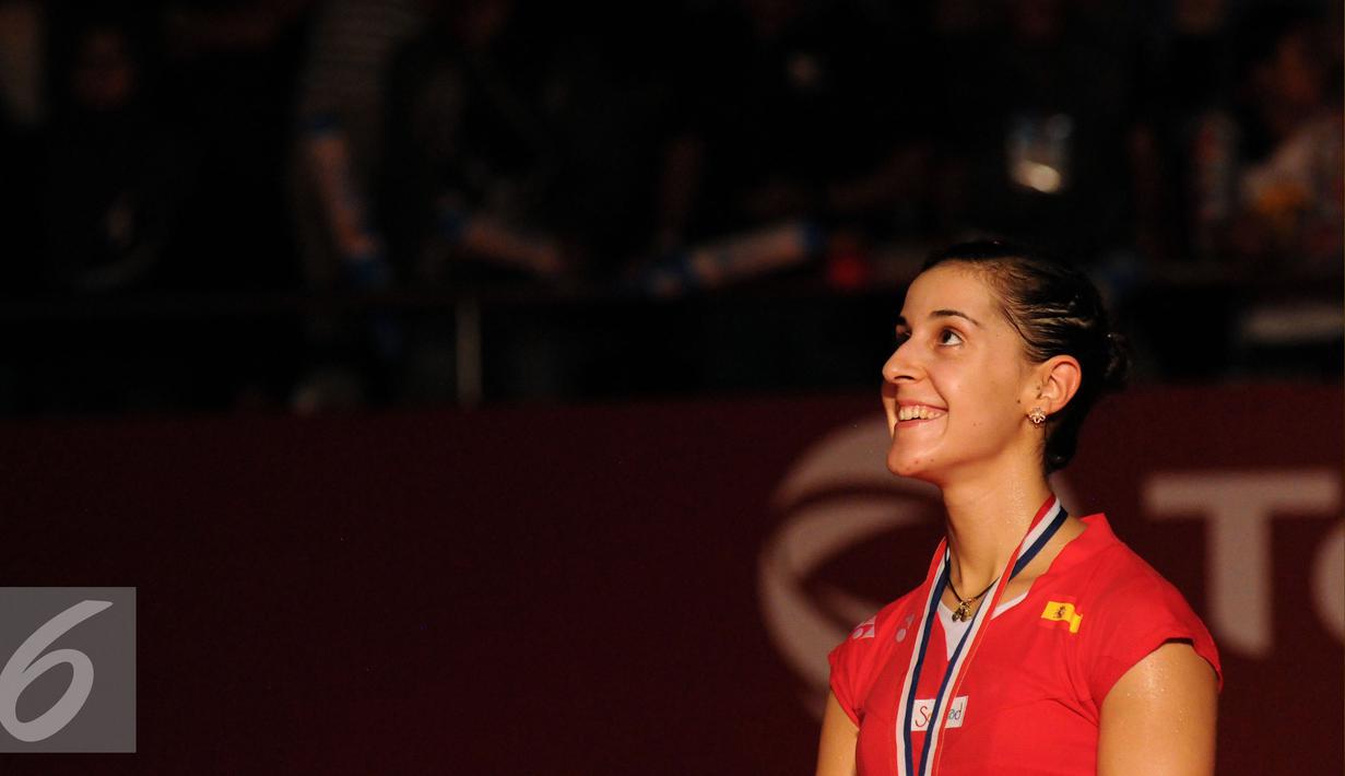 Carolina Marin (spanyol) tersenyum menyaksikan pengibaran bendera usai sukses mempertahankan gelar juara dunia bulutangkis tunggal putri setelah mengalahkan Saina Nehwal (India) di BWF 2015 di Jakarta, Minggu (16/8/2015). (Liputan6.com/Helmi Fithriansyah)