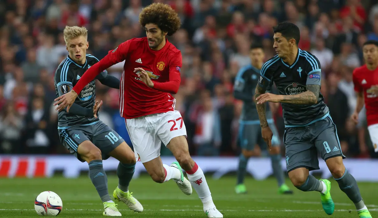 Gelandang Manchester United, Marouane Fellaini berusaha membawa bola dari kejara dua pemain Celta Vigo saat bertanding pada leg kedua Liga Europa di stadion Old Trafford, Inggris,(11/5). (AP Photo/Dave Thompson)