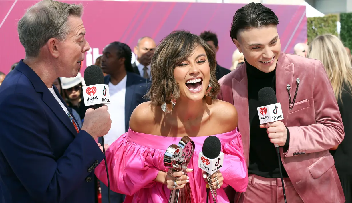 Penyanyi Agnez Mo (tengah) memegang piala iHeartRadio Music Awards 2019 di Los Angeles, California, AS, Kamis (14/3). Agnez Mo berhasil menyabet gelar juara kategori Social Star Award. (Phillip Faraone/Getty Images North America/AFP)