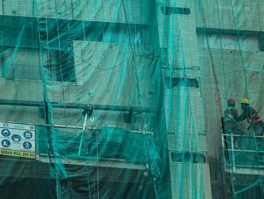 Pekerja konstruksi beraktivitas di proyek pembangunan gedung di Jakarta, Selasa (16/3/2021). BPJS Ketenagakerjaan mengungkapkan kasus kecelakaan kerja mencapai 153.044 sepanjang 2020 lalu. (merdeka.com/Imam Buhori)
