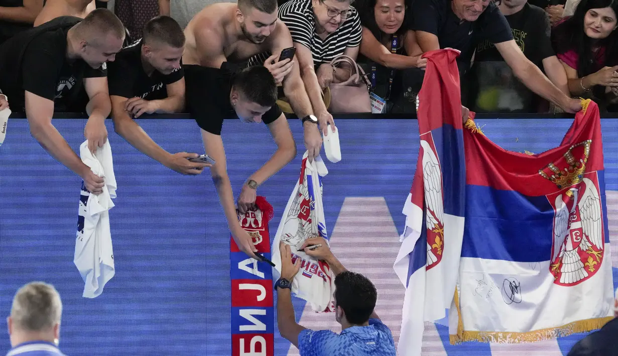 Petenis asal Serbia Novak Djokovic memberikan tanda tangan setelah mengalahkan Roberto Carballes Baena dari Spanyol pada pertandingan putaran pertama kejuaraan tenis Australia Terbuka di Melbourne, Rabu (18/1/2023). Berburu tanda tangan menjadi salah satu aktivitas fans yang menonton langsung Australian Open 2023. (AP Photo/Aaron Favila)