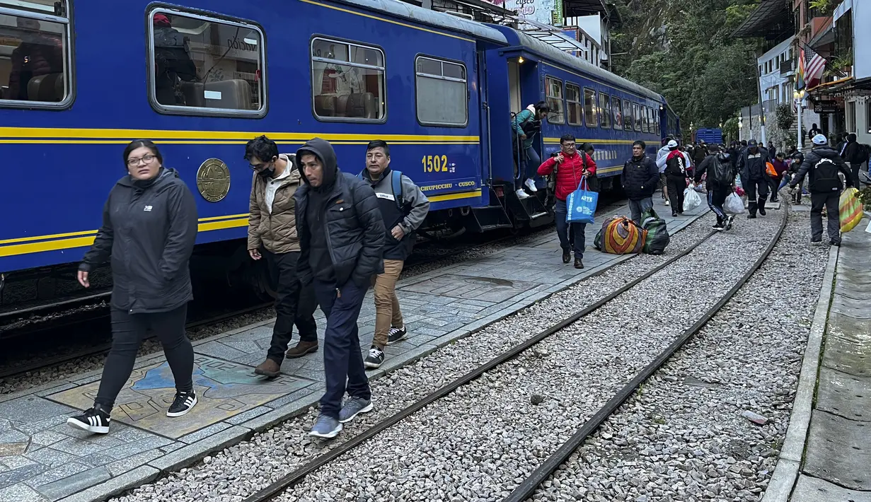 Penduduk dan pengunjung tiba di Machu Picchu, Peru dengan kereta pertama setelah layanan dari Ollantaytambo diperbarui, Rabu (8/2/2023). Layanan kereta api ke Machu Picchu di Peru sebagian diaktifkan kembali Rabu ini untuk mengangkut penduduk lokal, setelah penangguhan hampir tiga minggu karena blokade rel kereta api akibat protes anti-pemerintah yang mengguncang negara Andes. (Carolina Paucar / AFP)