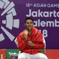 Jonatan Christie menunjukkan medali emas usai upacara penghargaan cabang olahraga badminton Asian Games 2018 di Jakarta, Selasa (28/8). Jonatan menang atas wakil Chinese Taipei, Chou Tienchen.  (AFP Photo/Sonny Tumbelaka)