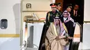 Pengawal membantu Raja Arab Saudi, Salman bin Abdulaziz Al Saud menuruni tangga eskalator saat tiba di Vnukovo International Airport, Rusia, 4 Oktober 2017. Eskalator emas milik Raja Salman macet setelah bergerak beberapa saat. (Alexander NEMENOV/AFP)