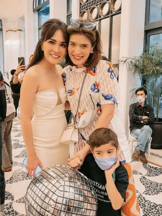 Carissa Puteri tampil santai dengan atasan bermotif dipadukan celana motif asimetrisnya. Ia membawa sling bag putih dan aksesori seperti anting dan kacamata hitamnya.  (@carissa_puteri)