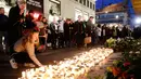 Lilin dan bunga diletakkan warga di lokasi terjadinya serangan truk sebagai bentuk ungkapan berkabung di Stockholm, Swedia, Minggu (9/4). Sebuah truk yang dibajak menabrakkan diri ke kerumunan pejalan kaki pada Sabtu (8/4). (AP Photo / Markus Schreiber)