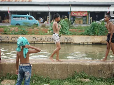 Anak-anak berenang di aliran Sungai Kalimalang, Jakarta, Selasa (18/8/2020). Keterbatasan ekonomi menyebabkan anak-anak tersebut memanfaatkan Sungai Kalimalang sebagai tempat berenang, meskipun berbahaya bagi keselamatan dan kesehatan mereka. (Liputan6.com/Immanuel Antonius)