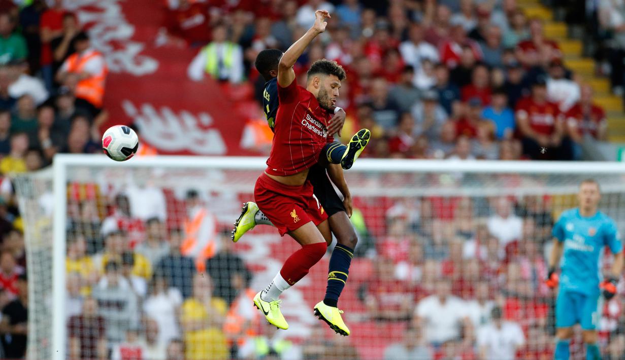 Pemain Liverpool Alex Oxlade-Chamberlain (depan) berebut bola udara dengan pemain Arsenal Ainsley Maitland-Niles (belakang) saat bertanding dalam Liga Inggris di Stadion Anfield, Liverpool, Inggris, Sabtu (24/8/2019). Liverpool menang 3-1 dan kukuh di puncak klasemen sementara. (AP Photo/Rui Vieira)