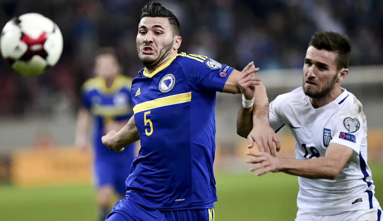 Duel Sead Kolasinac (kiri) dengan Yannis Gianniotas, Yunani pada Kualifikasi PIala Dunia 2018. (AFP/Angelos Tzortzinis)
