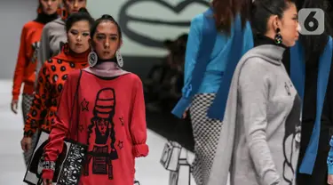 Model disabilitas mengenakan busana rancangan kolaborasi Cotton Ink x Intoart yang digawangi British Council pada Jakarta Fashion Week 2020 di Senayan, Kamis (24/10/2019). Kolaborasi ini menampilkan model disabilitas yang terdiri dari down syndrome, tuna daksa dan tuli. (Liputan.com/Johan Tallo)