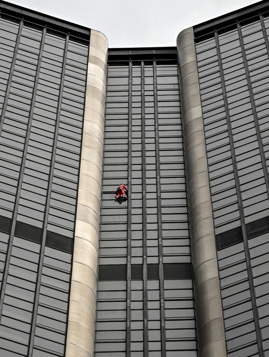 Alain Robert, pendaki bangunan pencakar langit asal Prancis memanjat Menara Montparnasse di Paris, Prancis, Rabu (12/10/2022). Alain Robert yang dikenal sebagai Spiderman Prancis itu kembali beraksi dengan memanjat Menara Montparnasse yang memiliki ketinggian 210 meter. (Bertrand GUAY/AFP)