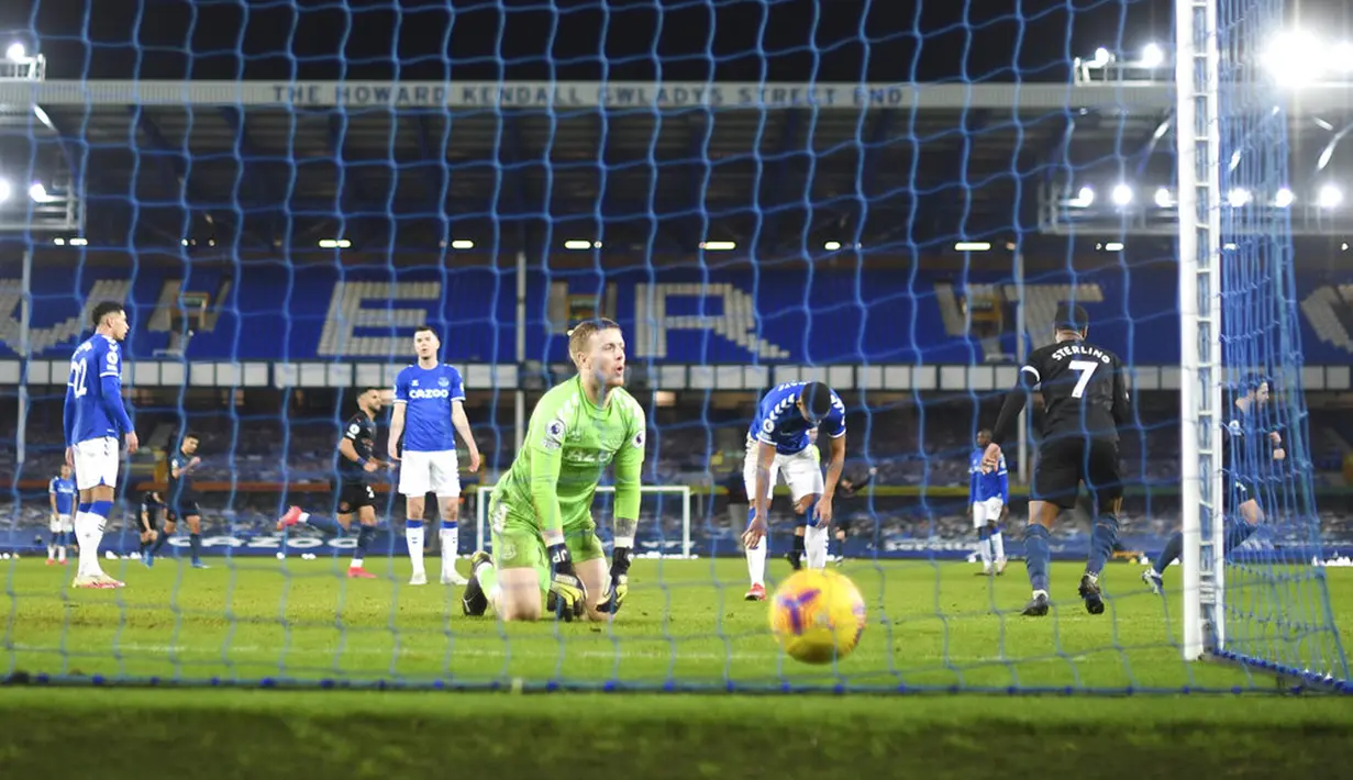 Kiper Everton Jordan Pickford (tengah) bereaksi setelah pemain Manchester City Bernardo Silva mencetak gol pada pertandingan Liga Inggris di Stadion Goodison Park, Liverpool, Inggris, Rabu (17/2/2021). Manchester City menang 3-1. (Michael Regan/Pool via AP)