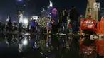 Warga memadati malam pergantian tahun di kawasan Bundaran HI, Jakarta, Minggu (31/12). Pemprov DKI Jakarta memberlakukan car free night di Jalan Sudirman hingga Thamrin. (Liputan6.com/Angga Yuniar)