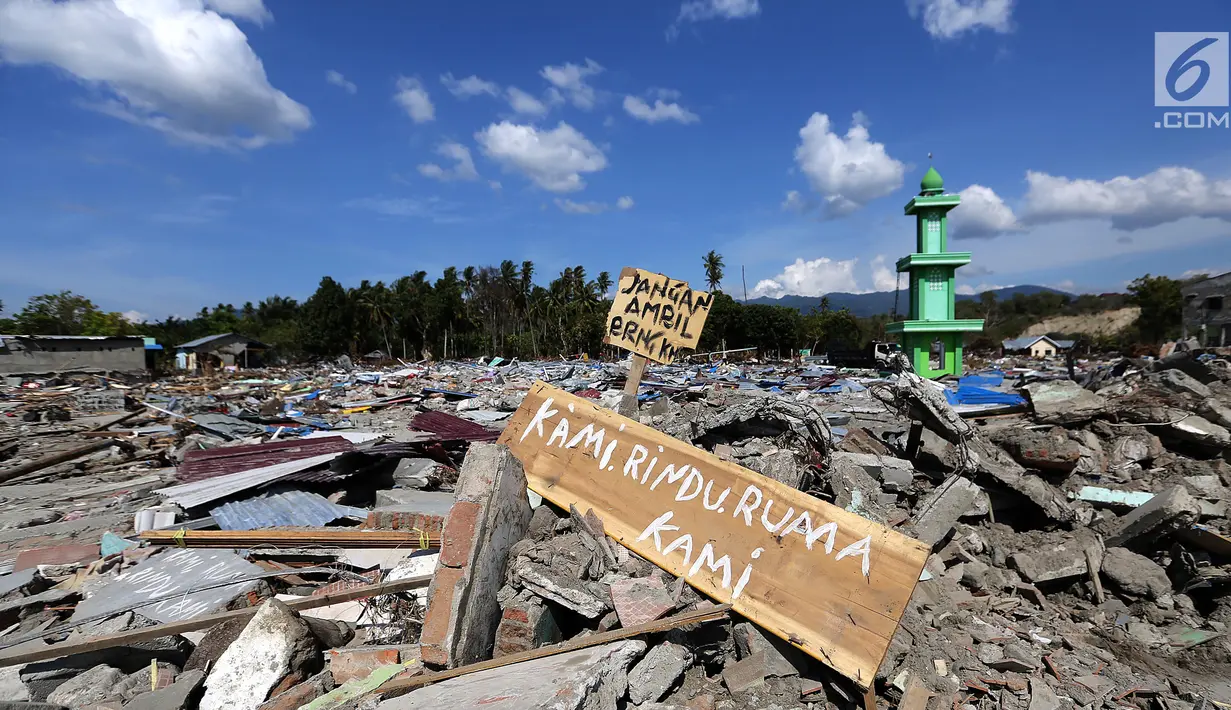 Sebuah papan dengan pesan Kami Rindu Rumah Kami dipasang pasca gempa bumi dan tsunami di pinggir Jalan Trans Sulawesi, Palu, Sulawesi Tengah, Kamis (4/10). (Liputan6.com/Fery Pradolo)