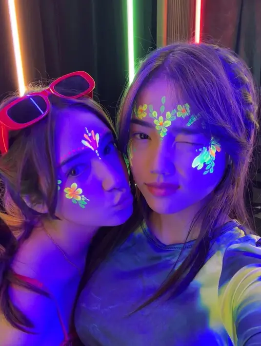 Gaya cantik Fuji saat menonton konser. Ia berpose imut mengedipkan satu matanya dengan riasan wajah bergambar bunga yang manis. [Foto: Instagram/fuji_an]