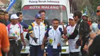 Petinju legendaris Indonesia, Nico Thomas, membawa obor Asian Games XVIII saat melintas di Kota Malang, Jawa Timur, Jumat (20/7/2018). Sebanyak 53 kota di Indonesia akan dilalui oleh obor Asian Games. (Bola.com/Iwan Setiawan)