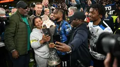 Pemain Atalanta, Ademola Lookman (tengah) merayakan gelar juara Liga Europa 2023/2024 bersama keluarganya setelah laga final melawan Bayer Leverkusen di Dublin Arena, Irlandia, Kamis (23/05/2024) dini hari WIB. (AFP/Paul Ellis)