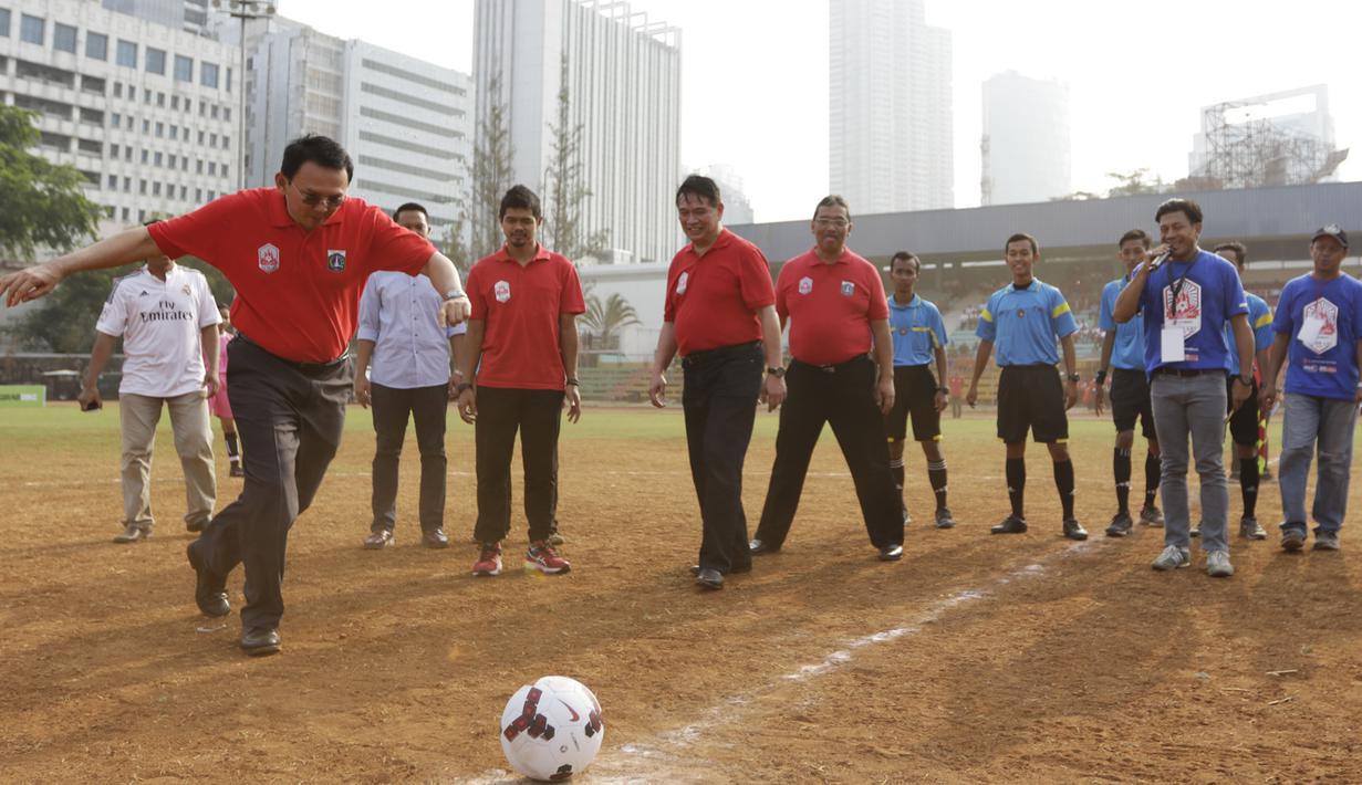 Gubernur DKI Jakarta, Basuki T Purnama menendang bola membuka Rusun Cup 2015 di Stadion Soemantri Brodjonegoro, Jakarta, Sabtu (24/10/2015). (Bola.com/Vitalis Yogi Trisna)