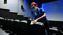 Pekerja mendisinfeksi kursi di bioskop yang dibuka kembali menyusul pelonggaran langkah-langkah yang diberlakukan oleh pemerintah Kolombia untuk menghentikan penyebaran Covid-19, di Cali, Kolombia pada Jumat (2/10/2020). (Photo by Luis ROBAYO / AFP)