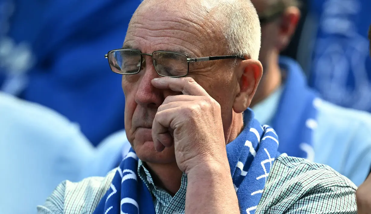 Seorang pendukung Everton menyeka air matanya saat upacara perpisahan setelah laga lanjutan Liga Inggris 2024/2025 melawan Southampton di Goodison Park, Liverpool, Inggris, Minggu (18/05/2025) waktu setempat. (AFP/Paul Ellis)