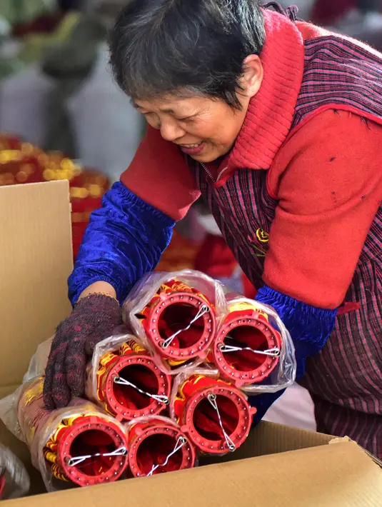 Seorang pekerja mengemas lentera merah menjelang perayaan Tahun Baru Imlek 2020 di sebuah pabrik di Wuyi, China, Kamis (26/12/2019). Beberapa keunikan pada tradisi perayaan Imlek yang masih dijalani warga Tionghoa adalah menggantung lentera merah. (Photo by STR / AFP)