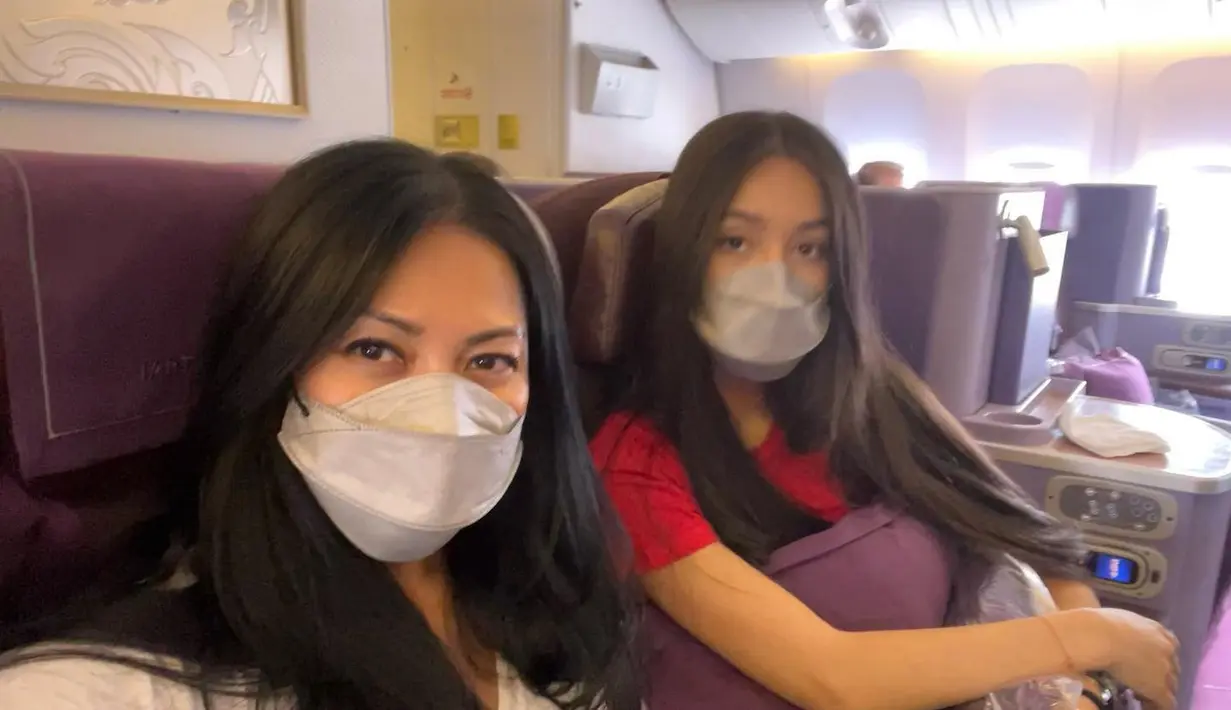 Anggun C Sasmi dan Kirana di dalam pesawat. Meski mengenakan masker, wajak Kirana masih tampak sangat mirip dengan ibunya. (Foto: Instagram/ anggun_cipta)